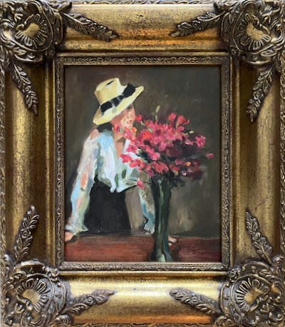 vrouw met hoed, witte blouse en donkere rok staand achter een grote vaas met rode bloemen
